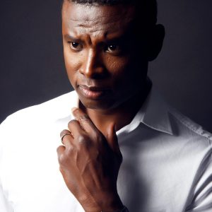 Portrait of a thoughtful man in a crisp white shirt with a serious expression.